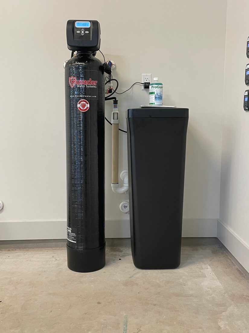 Crusader Water Systems softener with brine tank installed against a garage wall