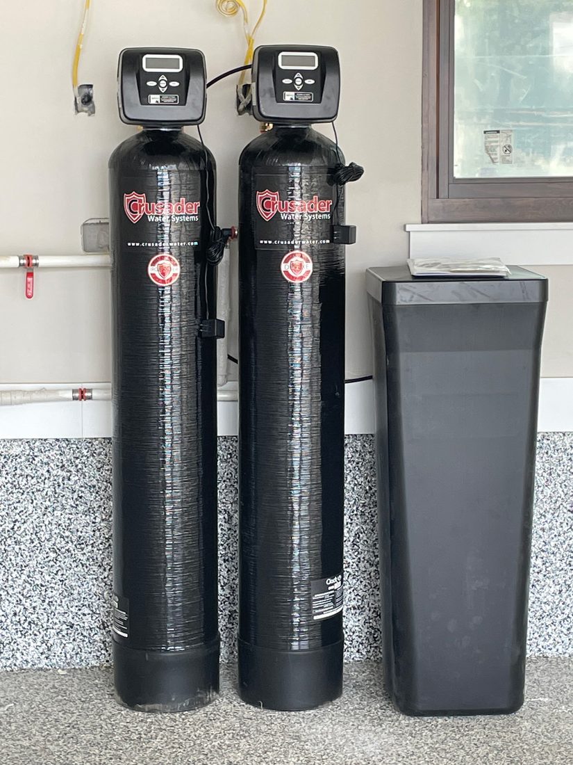 Dual-tank Crusader water softener and filtration system installed in a Central Texas garage
