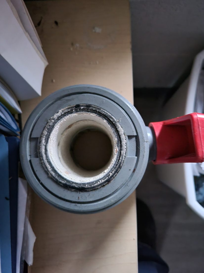Calcium sulfate scale built up on a plastic PVC filter housing